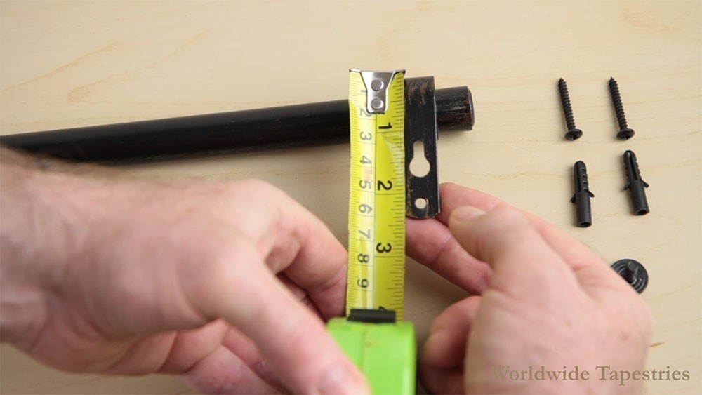 Measure the distance from the top and side of the tapestry, to the bracket's upper screw hole